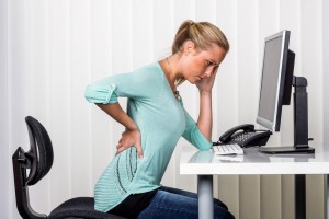 woman with back pain in the office